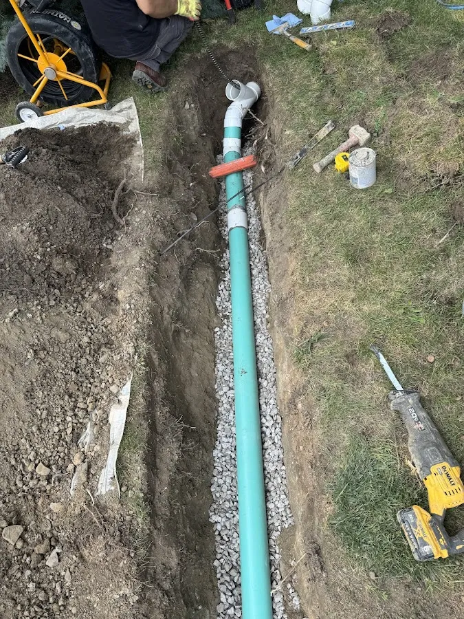 Aerial view of blue sewer pipe installation in trench with workers and equipment