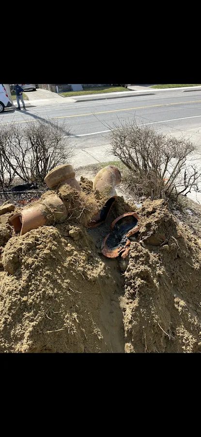 Blue drainage pipe being installed in basement foundation with staircase visible above