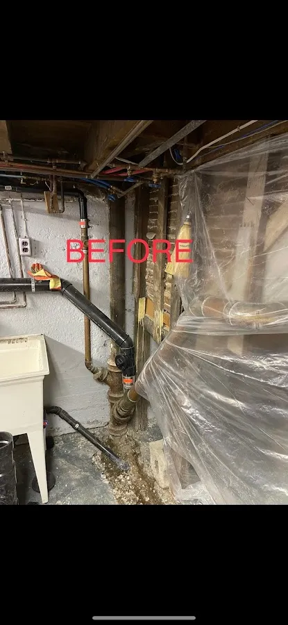 Water-damaged basement showing exposed framing, wet surfaces, and plastic containment during flood restoration process