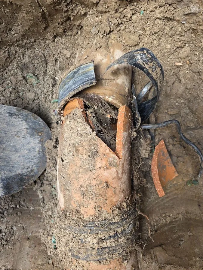 Corroded and damaged drain pipe fitting showing mineral deposits and deterioration