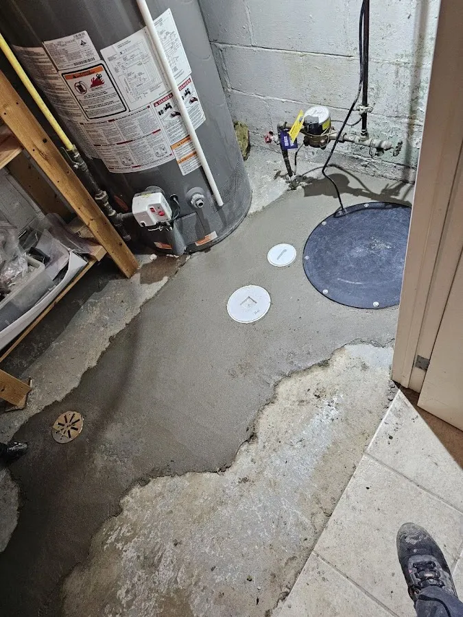Water heater and basement plumbing fixtures with electrical connections and drains